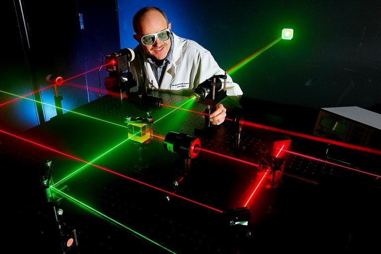 Naval electronics engineer Daniel King prepares alignment of various optical components using eye-safe visible lasers.